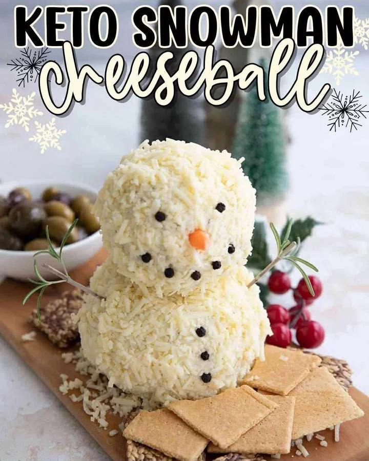Keto Snowman Cheeseball decorated with festive toppings and herbs