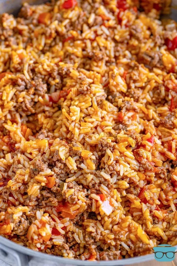 A colorful plate of Taco Rice topped with fresh ingredients and seasonings.